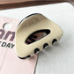 Beau claw clip placed on a white surface highlighting its oval shape