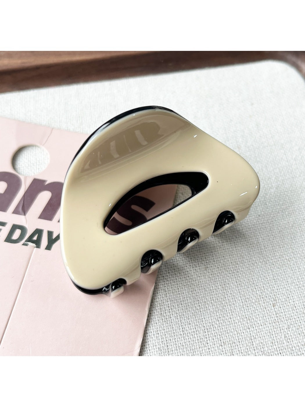 Beau claw clip placed on a white surface highlighting its oval shape