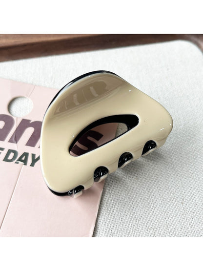 Beau claw clip placed on a white surface highlighting its oval shape