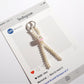 Keypus cute bow keychain placed on a wooden surface showing bead details