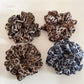 Close-up of vintage leopard print ruched scrunchie on white background