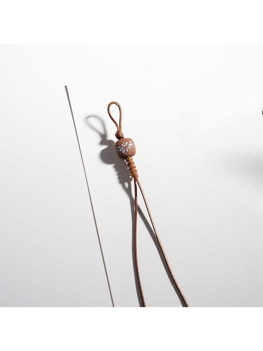 Brown cartoon keychain hanging from a silver keyring on a white background