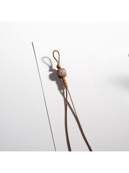 Brown cartoon keychain hanging from a silver keyring on a white background