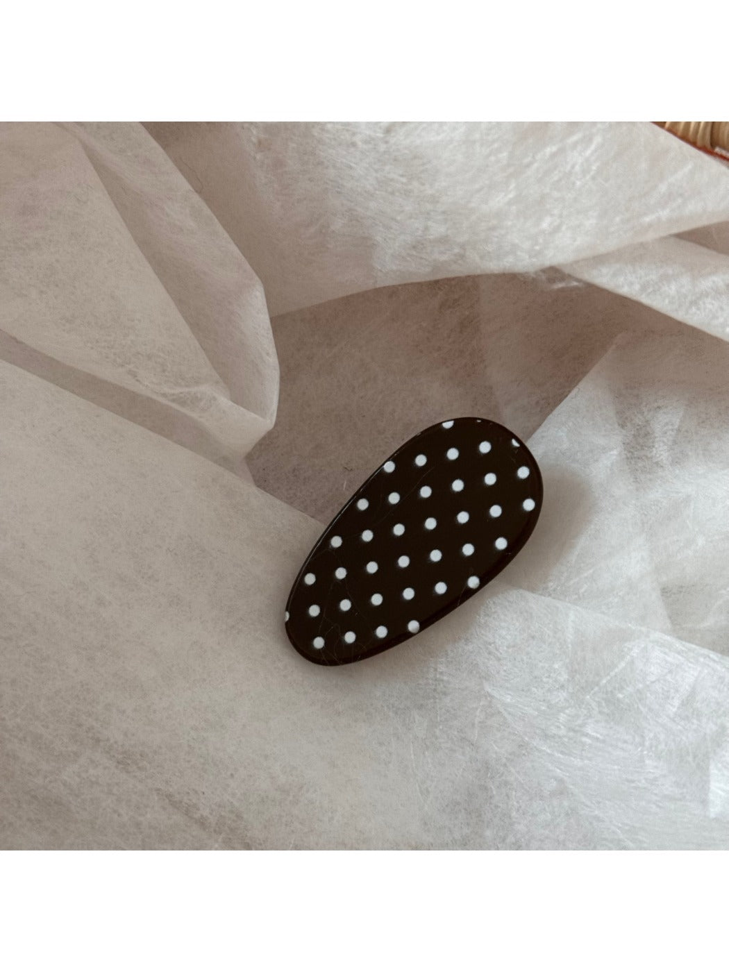 Beau oval polka dot hair clip held in hand showing size and shape