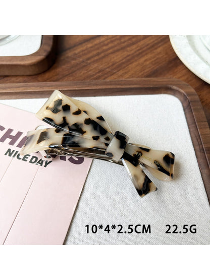 Beau elegant bow hair clip photographed from above showing symmetrical shape