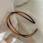 Gifty irregular acrylic headband displayed on wooden surface with soft lighting