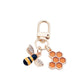 Side angle of bee and honeycomb shaped keychain with metal ring