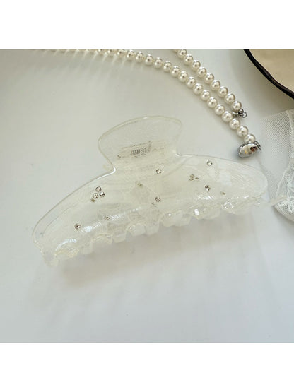 Beau hair claw clip resting on a wooden surface with soft lighting