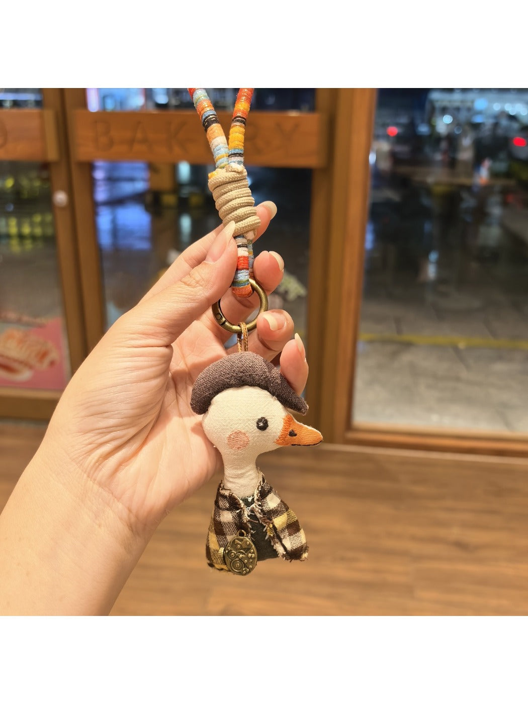 Side view of the duck charm showing its smooth enamel finish and metal ring