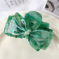 Beau bow shaped claw clip with light reflecting off smooth surface