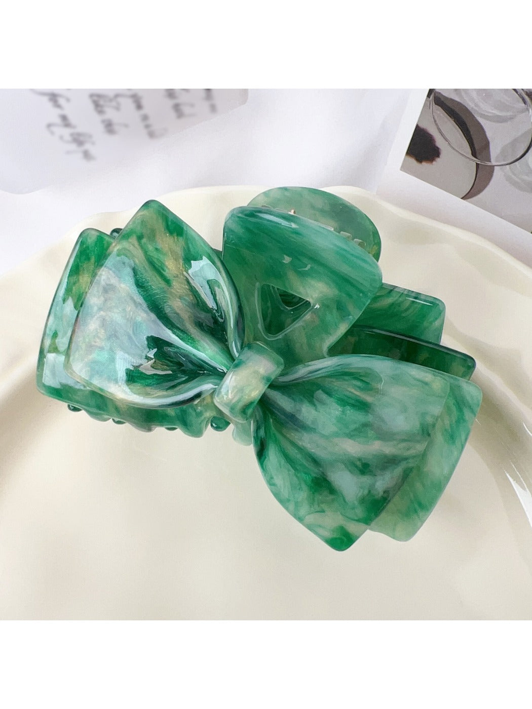 Beau bow shaped claw clip with light reflecting off smooth surface