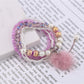 Side view of Lovra pompom pendant bracelet displaying bead arrangement and charm