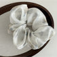 Gifty printed satin hair scrunchie on a neutral background showing elastic stretch