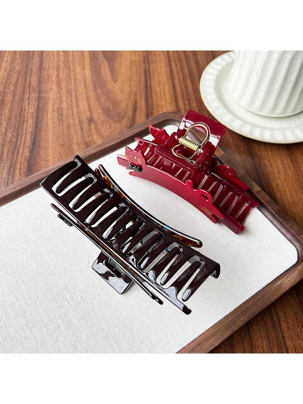 Beau claw clip open, displaying metal spring mechanism and cat design