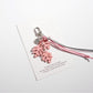 Green Keypus leaf shaped keychain placed next to a smartphone