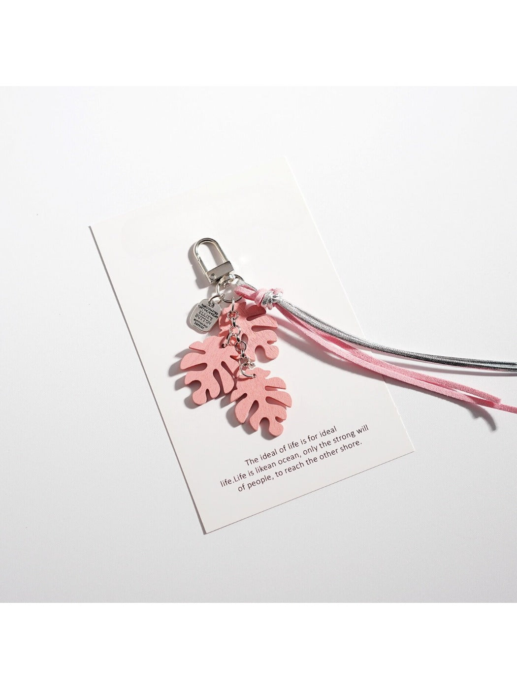 Green Keypus leaf shaped keychain placed next to a smartphone