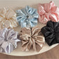 Classic glossy satin scrunchie in soft pink on white background
