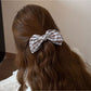 Model wearing Beau elegant bow banana clip in black, styled in long hair