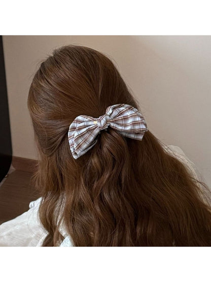 Model wearing Beau elegant bow banana clip in black, styled in long hair