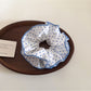 Close-up of delicate blue polka dot scrunchie on white background