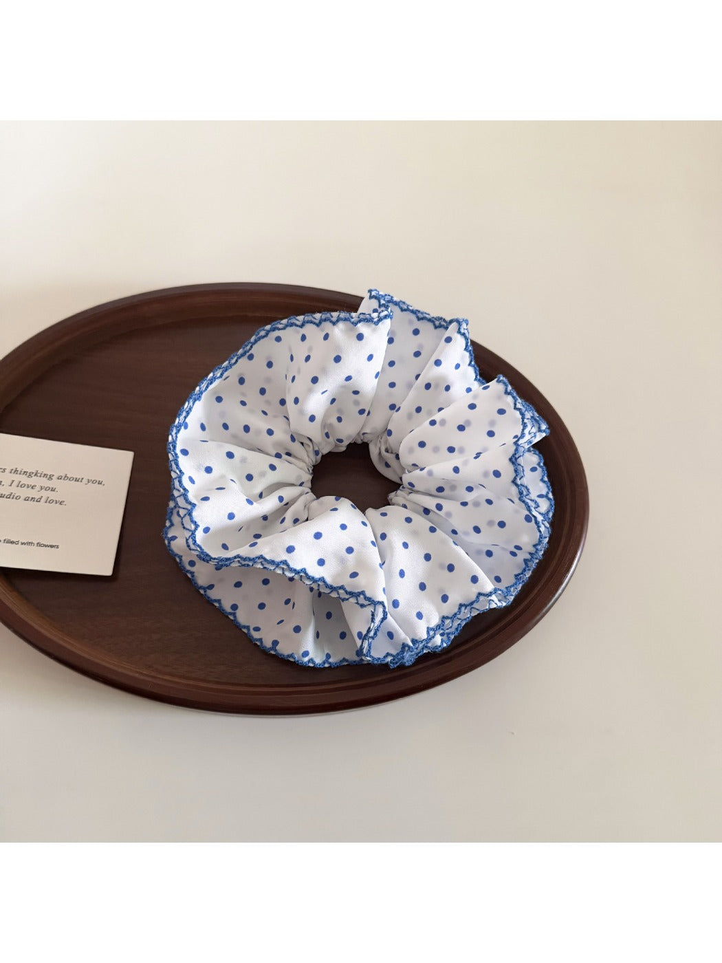 Close-up of delicate blue polka dot scrunchie on white background