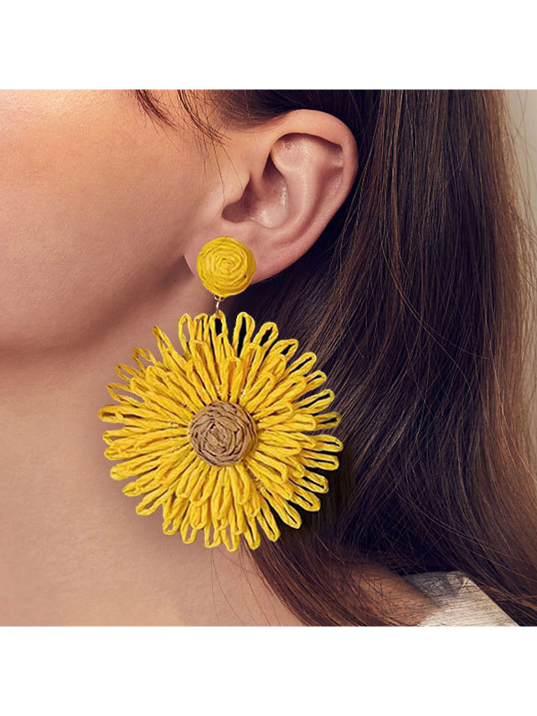 Model wearing colorful floral raffia statement drop earrings with a white top