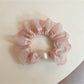 Pink mini scrunchie packaged in a clear plastic bag with branding