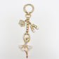 Keychain with ballerina charm next to a smartphone for size comparison