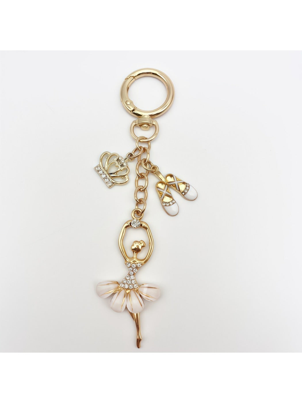 Keychain with ballerina charm next to a smartphone for size comparison