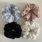 Gifty Sweet Cutout Lace Scrunchie displayed on a wooden surface showing its texture and cutout details