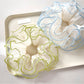 Close-up of Gifty Natural Misty Mesh Scrunchie in soft beige fabric