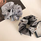 Close-up of Gifty scrunchie showing detailed plaid and patchwork fabric textures