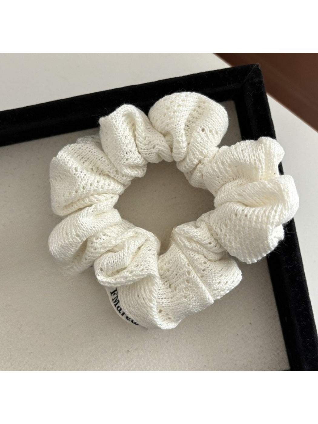 Gifty Lazy Style scrunchie laid flat, emphasizing the openwork fabric and stitching details