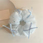 Close-up of blue tulle bow scrunchie showing soft texture and ribbon layers