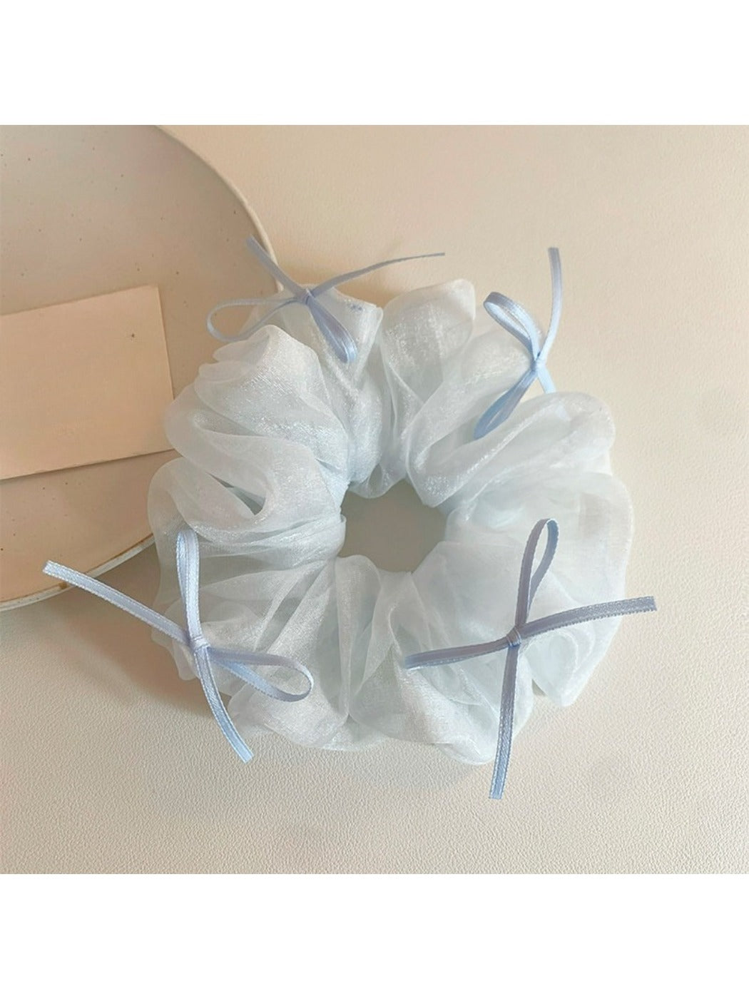 Close-up of blue tulle bow scrunchie showing soft texture and ribbon layers