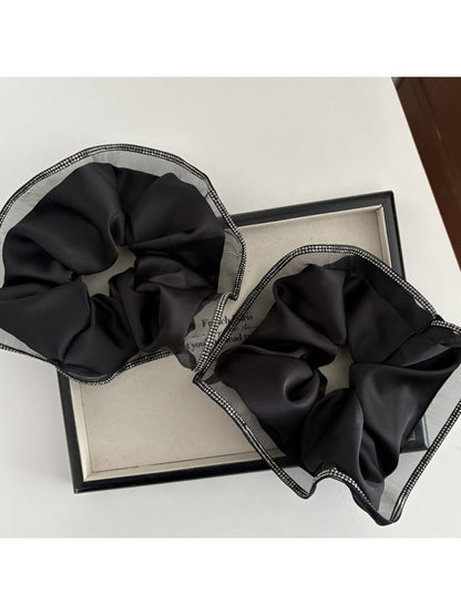Gifty scrunchie styled on a wrist as a fashion accessory with neutral tones
