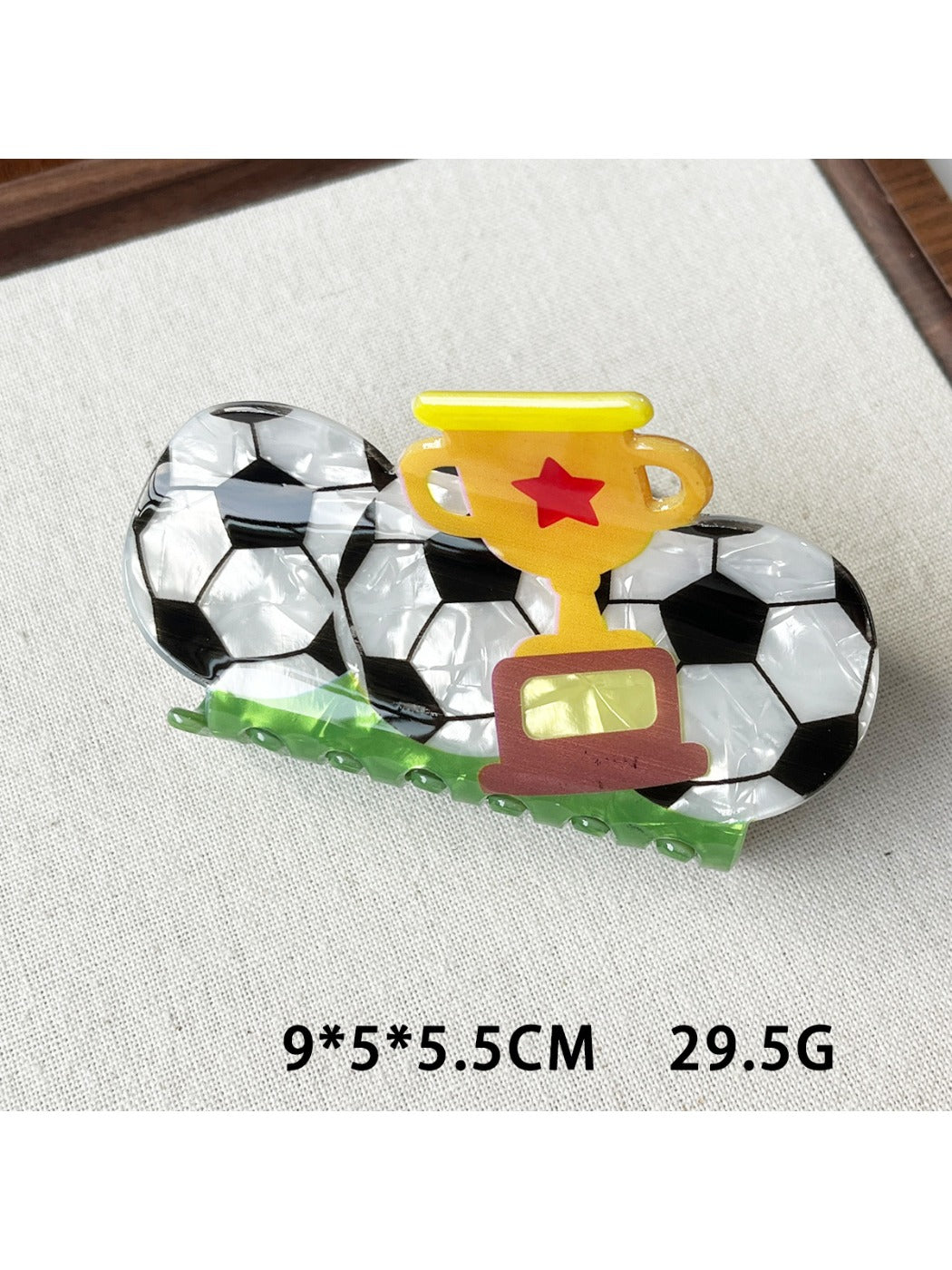 Beau claw clip featuring a soccer ball pattern with visible spring mechanism