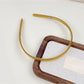 Gifty headband in pastel color placed on wooden surface