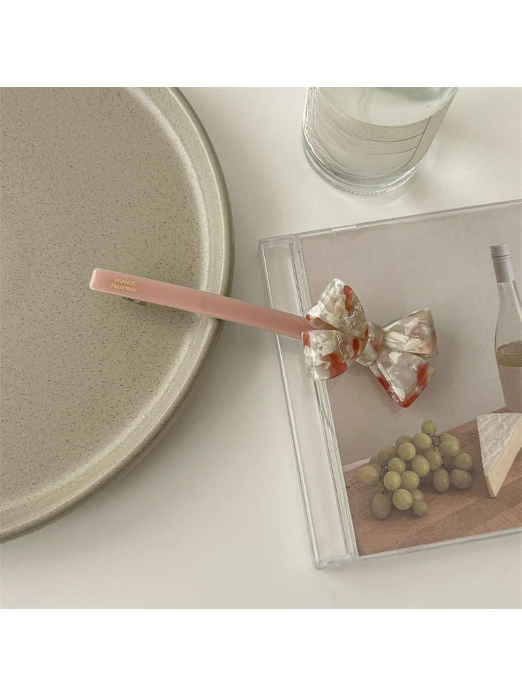 Beau bow bar hair clip placed on wooden surface emphasizing natural acetate texture