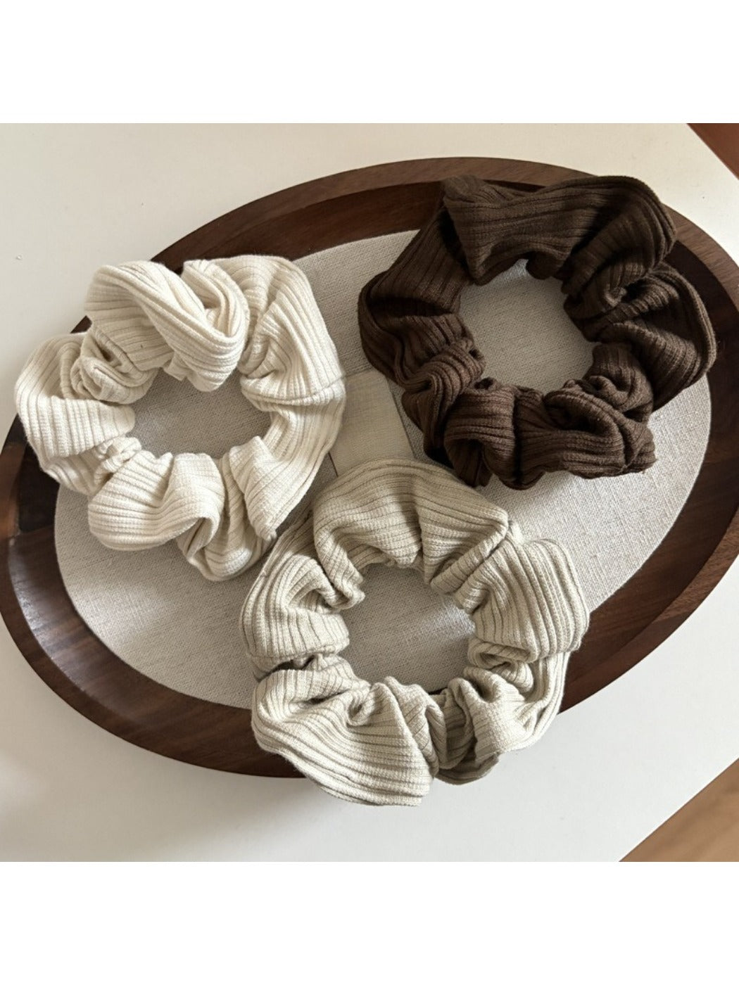 Gifty scrunchie wrapped around a ponytail on a model with brown hair