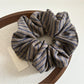 Gifty scrunchie held in hand highlighting its elasticity and design