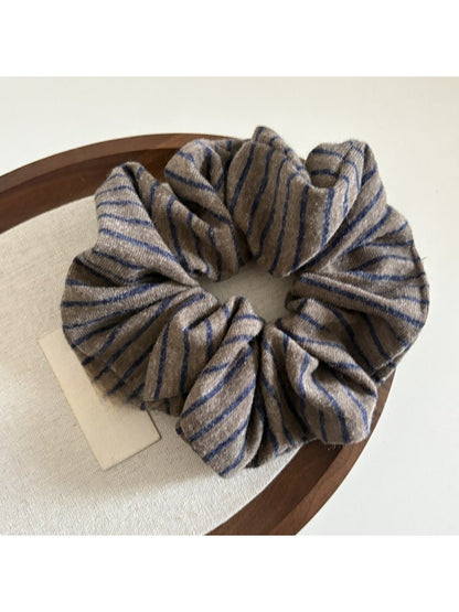 Gifty scrunchie held in hand highlighting its elasticity and design