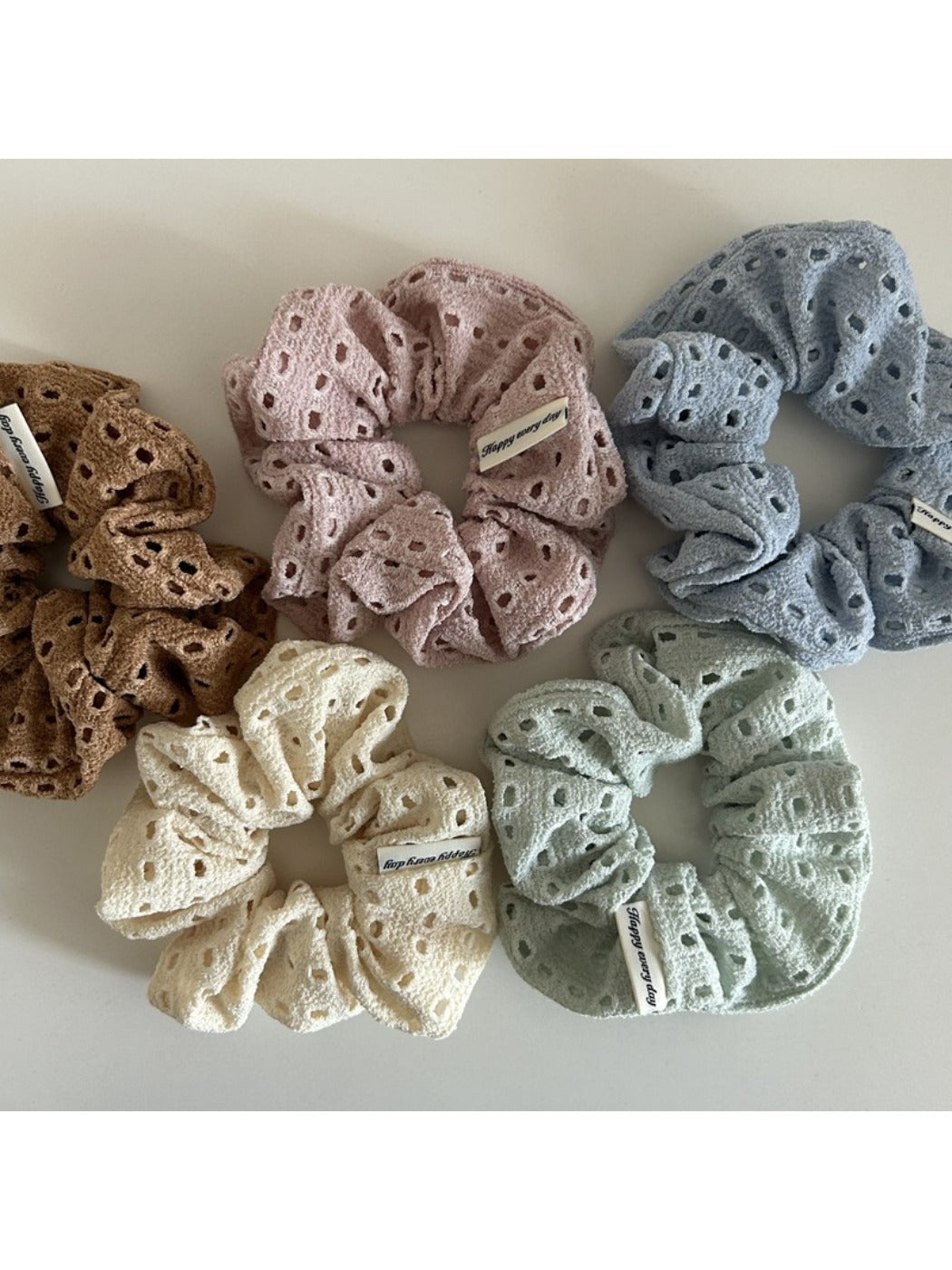 Soft chic dot cutout scrunchie in light beige fabric with small circular cutouts
