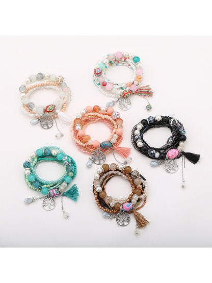Lovra bracelet with tree-shaped tassel pendant and multicolored beads on a white background