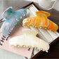 Beau plastic updo claw clip open, displaying the spring mechanism and teeth