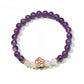 Lovra vintage floral beaded bracelet styled with other jewelry on a wooden surface