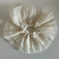 Beige lace scrunchie wrapped around wrist as a stylish accessory
