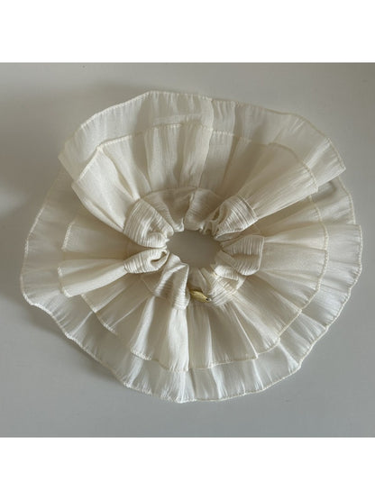Beige lace scrunchie wrapped around wrist as a stylish accessory