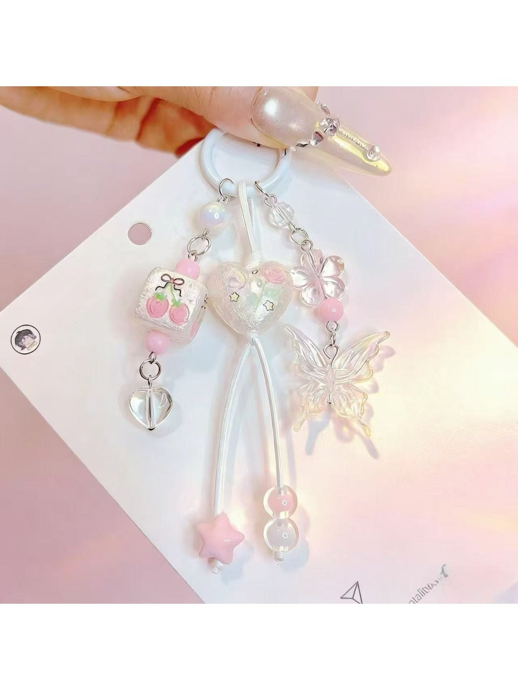 Heart shaped butterfly charm keychain with silver metal ring on white background