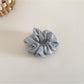 Satin bow scrunchie on a wooden surface with soft natural lighting